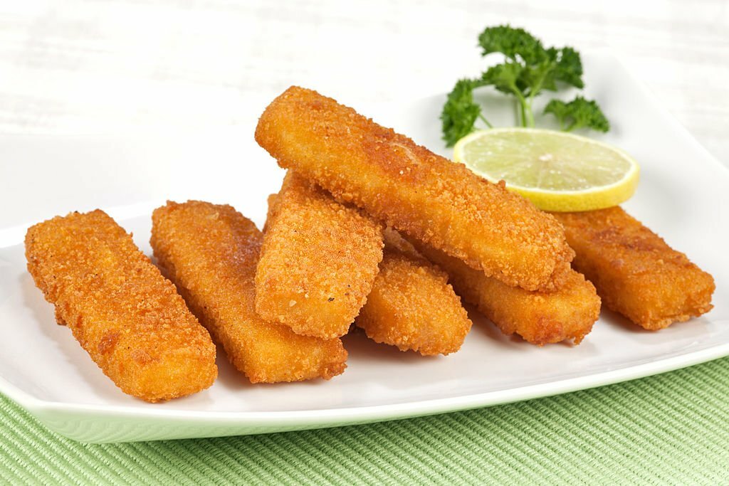 Fried fish fingers on a plate. Selective focus, shallow DOF.