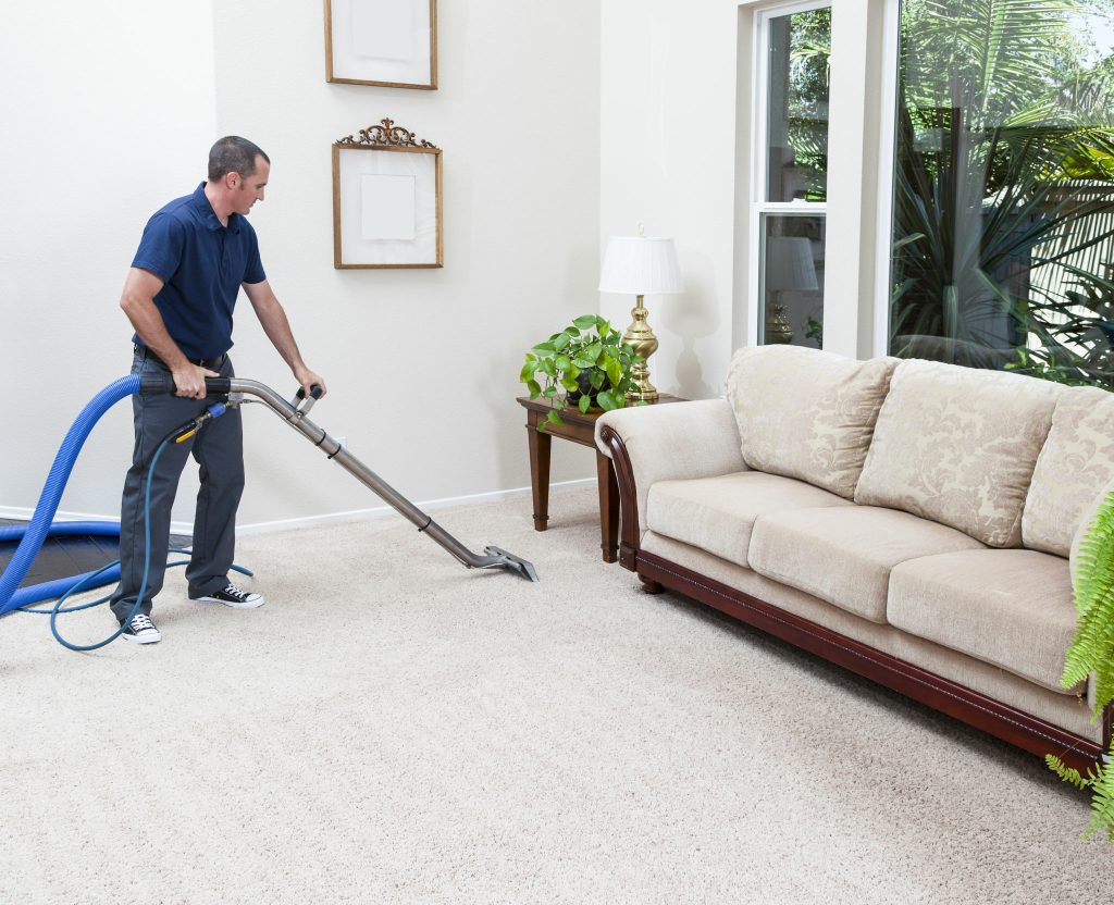 Man cleaning carpets in the home